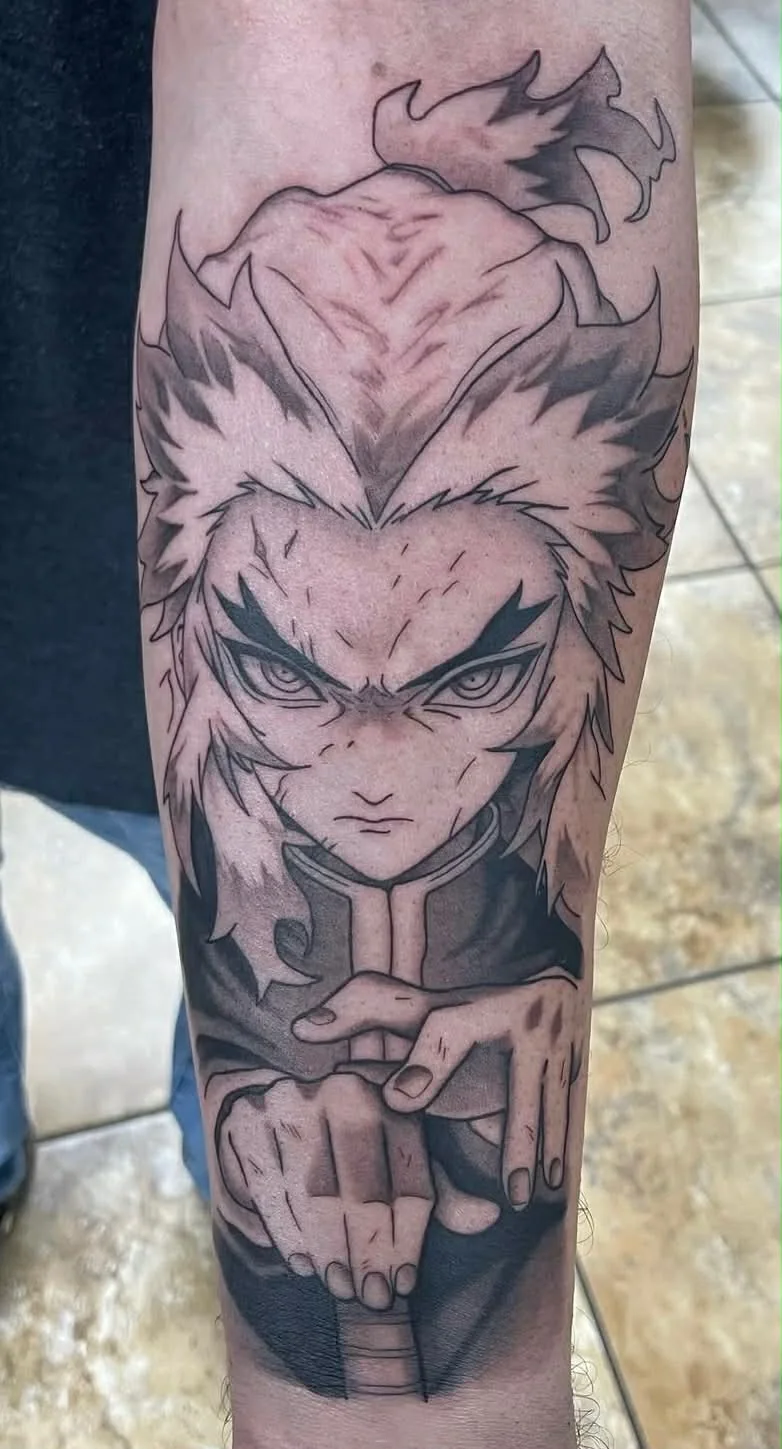 Black and grey anime character tattoo on forearm